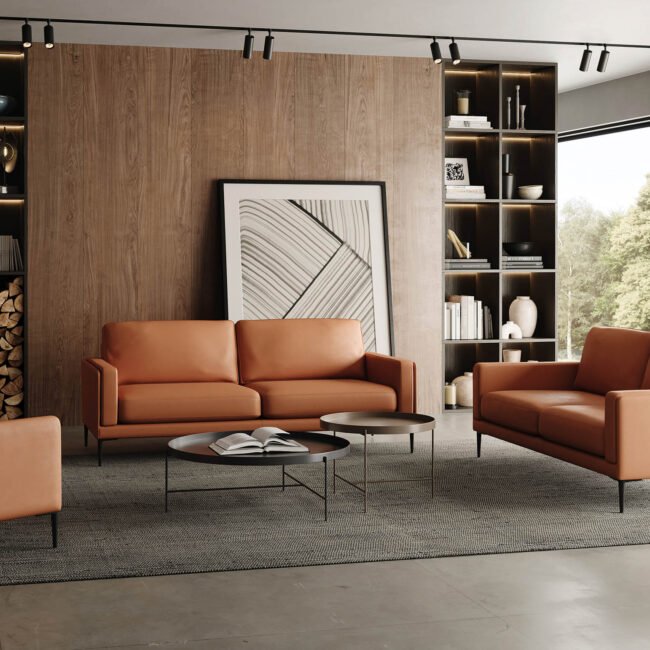 Un salon moderne avec des canapés en cuir marron AUTEUIL, trois tables basses rondes et une grande œuvre d'art abstraite. Des étagères en bois remplies de livres et d'objets décoratifs encadrent une pile de bois de chauffage, tandis que de grandes fenêtres offrent une vue sur la verdure luxuriante à l'extérieur. Meubles Barret Bordeaux